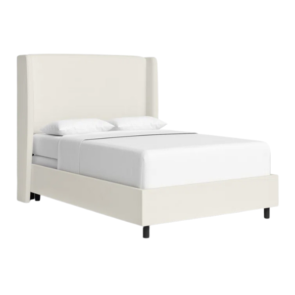 White linen upholstered king size bed with foam-padded wingback headboard, black low-profile metal legs, and sturdy wood frame.

