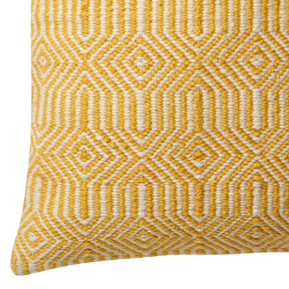 Yellow and cream geometric throw pillow on a bright outdoor chair with summer decor

